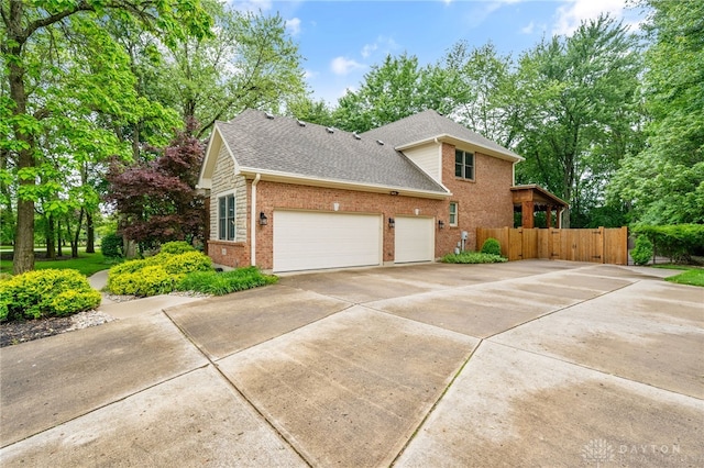 7607 Stone Ridge Dr, Springboro, OH 45066 - view of home's exterior featuring concrete driveway, brick siding, a shingled roof, and an attached garage