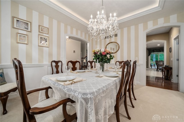 7607 Stone Ridge Dr, Springboro, OH 45066 - dining space featuring arched walkways, light colored carpet, wallpapered walls, a chandelier, and ornamental molding