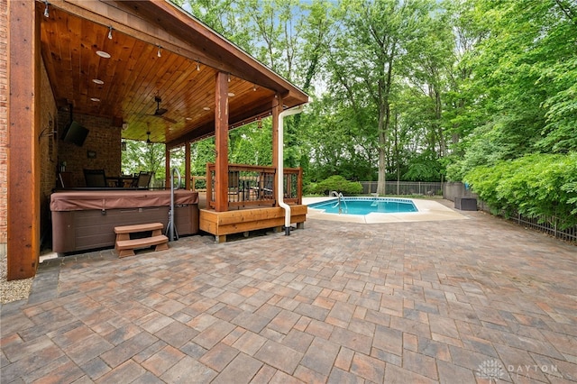 7607 Stone Ridge Dr, Springboro, OH 45066 - view of swimming pool with a hot tub, a patio area, a fenced backyard, a ceiling fan, and view of scattered trees