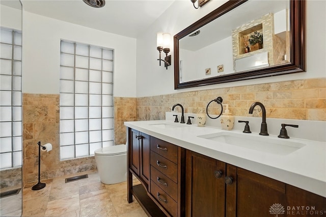 450 Ridgewood Ave, Oakwood, OH 45409 - full bathroom featuring tile walls, toilet, double vanity, and a wainscoted wall