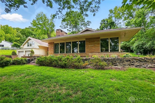 450 Ridgewood Ave, Oakwood, OH 45409 - rear view of property featuring a garage, a lawn, and a chimney