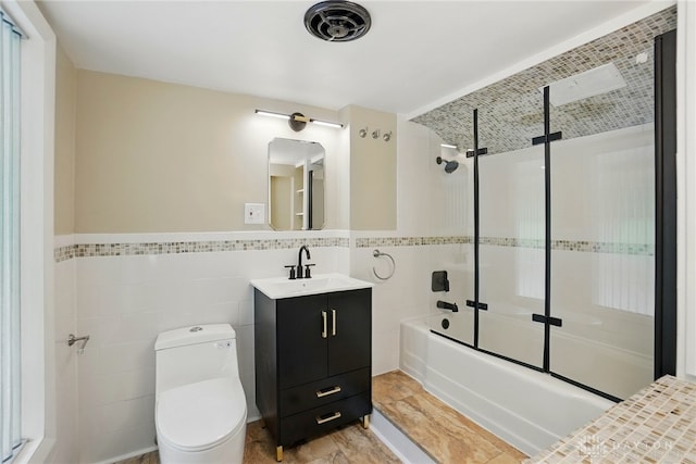450 Ridgewood Ave, Oakwood, OH 45409 - bathroom with tile walls, vanity, combined bath / shower with glass door, toilet, and wainscoting