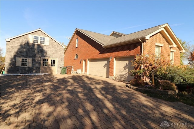 9543 Hacker Farm Ln, Centerville, OH 45458 - view of side of property with a garage, decorative driveway, and brick siding