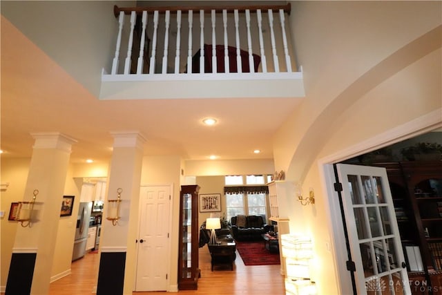 9543 Hacker Farm Ln, Centerville, OH 45458 - hallway with light wood-type flooring, recessed lighting, ornate columns, and a high ceiling