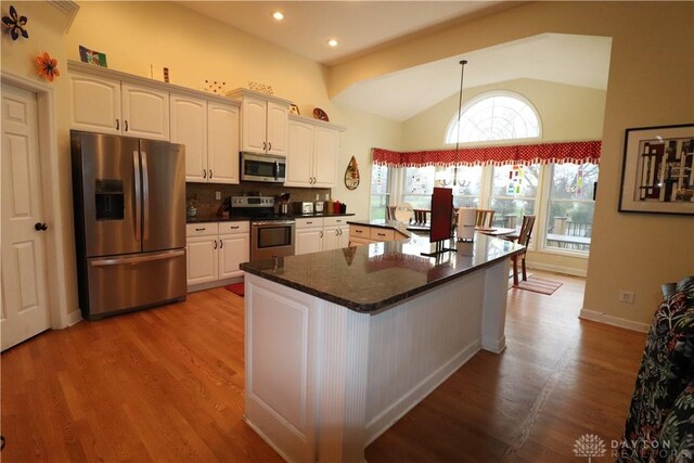 9543 Hacker Farm Ln, Centerville, OH 45458 - kitchen with stainless steel appliances, lofted ceiling, dark countertops, wood finished floors, and decorative backsplash