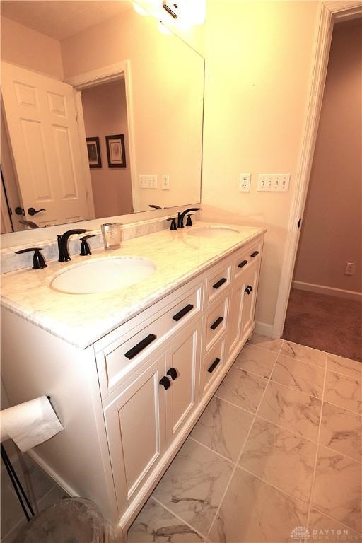 9543 Hacker Farm Ln, Centerville, OH 45458 - bathroom featuring double vanity, marble finish floors, and baseboards
