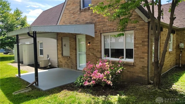 413 W Lake Ave, New Carlisle, OH 45344 - rear view of house featuring brick siding, a patio, and a shingled roof