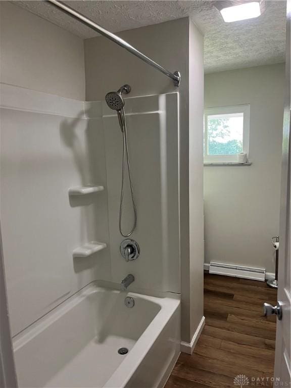 8700 Adams Rd, Dayton, OH 45424 - bathroom with a baseboard heating unit, a textured ceiling, wood finished floors, shower / bathtub combination, and baseboards