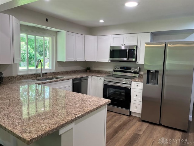 8700 Adams Rd, Dayton, OH 45424 - kitchen featuring appliances with stainless steel finishes, a sink, white cabinets, a peninsula, and light stone countertops