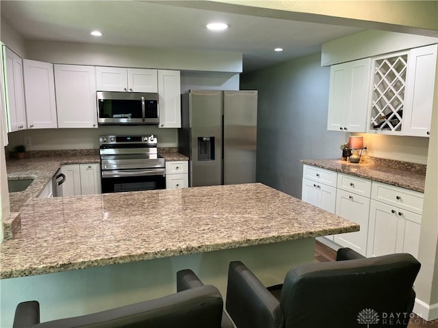 8700 Adams Rd, Dayton, OH 45424 - kitchen with appliances with stainless steel finishes, a kitchen breakfast bar, white cabinetry, and recessed lighting
