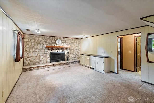5135 Lamonte Dr, Fairfield, OH 45014 - unfurnished living room featuring carpet floors, a stone fireplace, wood walls, and crown molding