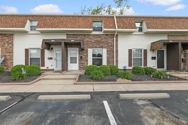1050 Frederick Dr, Xenia, OH 45385 - view of front of property with mansard roof, uncovered parking, brick siding, and roof with shingles