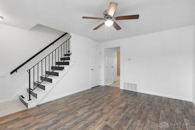 1050 Frederick Dr, Xenia, OH 45385 - unfurnished living room with stairs, a ceiling fan, wood finished floors, and baseboards