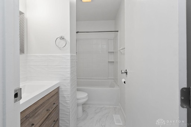 1050 Frederick Dr, Xenia, OH 45385 - bathroom with vanity, toilet, marble finish floors, and bathing tub / shower combination