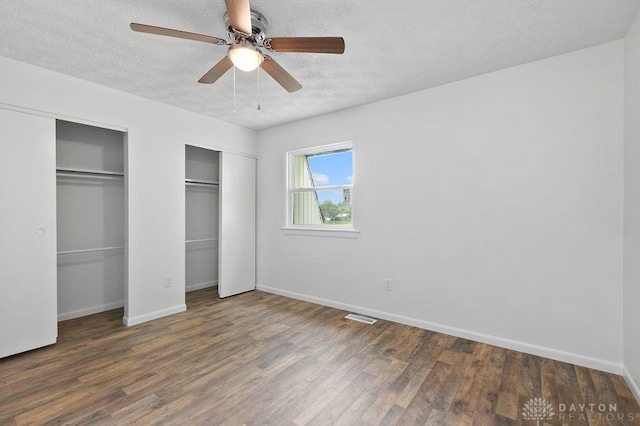 1050 Frederick Dr, Xenia, OH 45385 - unfurnished bedroom with multiple closets, a textured ceiling, wood finished floors, baseboards, and ceiling fan