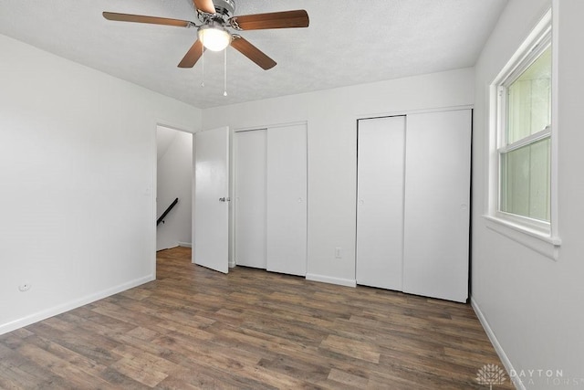 1050 Frederick Dr, Xenia, OH 45385 - unfurnished bedroom featuring multiple closets, wood finished floors, baseboards, and ceiling fan