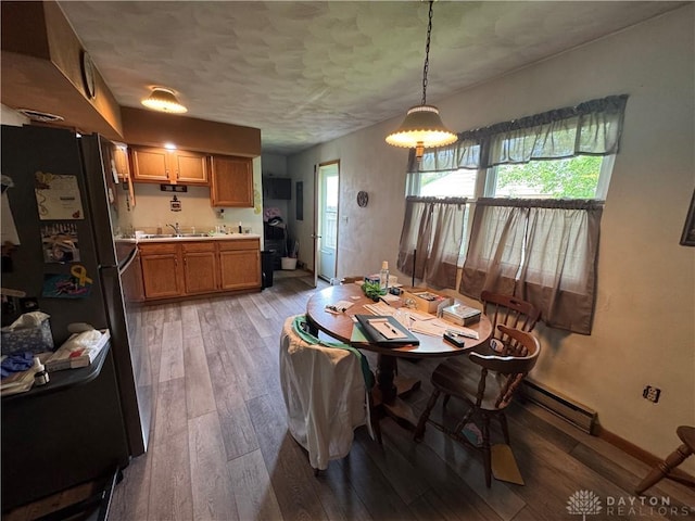 326 Little League Dr, Eaton, OH 45320 - dining space with baseboard heating, light wood-type flooring, healthy amount of natural light, baseboards, and a textured ceiling
