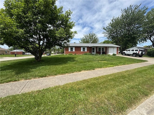 326 Little League Dr, Eaton, OH 45320 - single story home with a front lawn, driveway, a garage, and brick siding