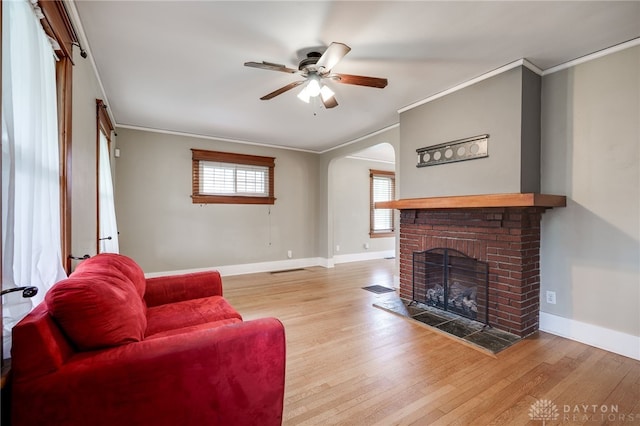 1809 Shroyer Rd, Oakwood, OH 45419 - living area featuring crown molding, a ceiling fan, wood finished floors, a brick fireplace, and arched walkways