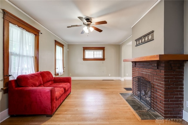 1809 Shroyer Rd, Oakwood, OH 45419 - living room featuring ornamental molding, a ceiling fan, light wood-type flooring, and a brick fireplace