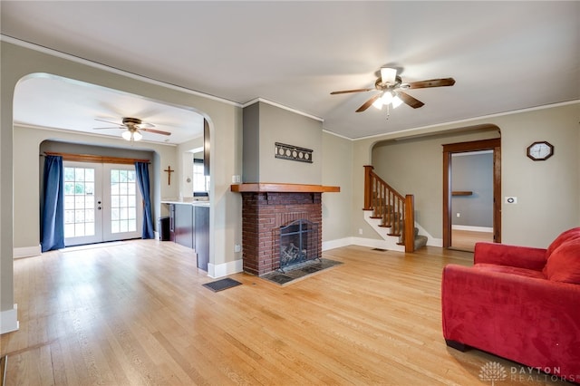 1809 Shroyer Rd, Oakwood, OH 45419 - living room featuring ceiling fan, arched walkways, a fireplace, light wood-type flooring, and ornamental molding