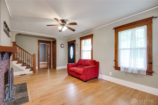 1809 Shroyer Rd, Oakwood, OH 45419 - foyer with a brick fireplace, a ceiling fan, light wood finished floors, arched walkways, and stairs