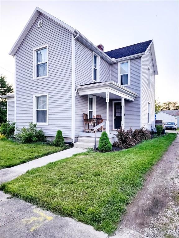 304 W Walnut St, Botkins, OH 45306 - traditional home with a porch, a front lawn, and a chimney