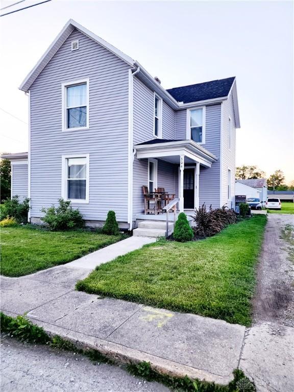 304 W Walnut St, Botkins, OH 45306 - traditional-style home featuring covered porch and a front lawn