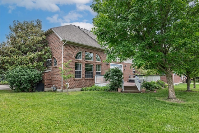6265 Amberley Ct, Liberty Twp, OH 45044 - view of front of house with brick siding, a front lawn, a deck, and a shingled roof