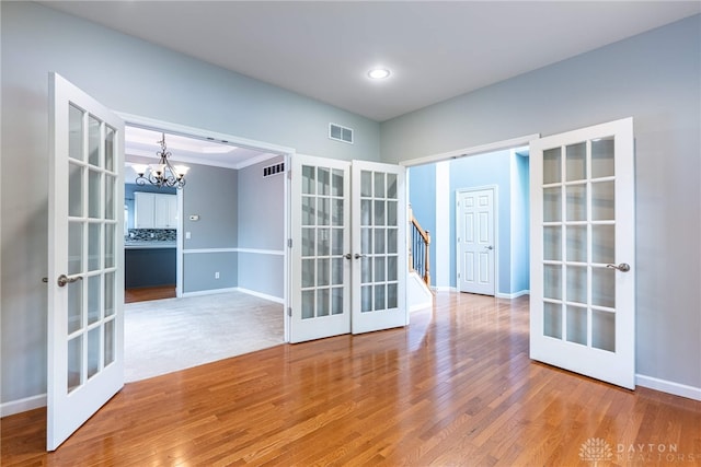 6265 Amberley Ct, Liberty Twp, OH 45044 - empty room featuring french doors, a chandelier, baseboards, wood finished floors, and crown molding