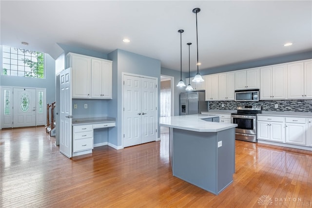 6265 Amberley Ct, Liberty Twp, OH 45044 - kitchen with stainless steel appliances, light wood-type flooring, white cabinetry, tasteful backsplash, and light countertops