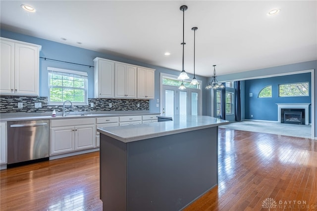 6265 Amberley Ct, Liberty Twp, OH 45044 - kitchen with dishwasher, a sink, open floor plan, backsplash, and light countertops