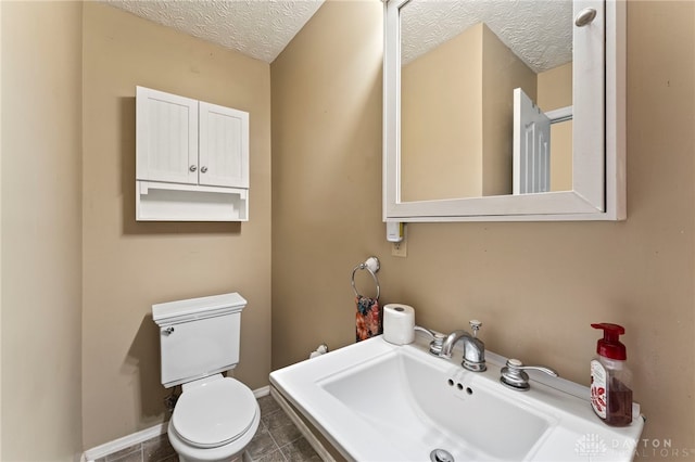 668 Dakota Dr, Xenia, OH 45385 - bathroom with a textured ceiling, toilet, baseboards, a sink, and tile patterned floors