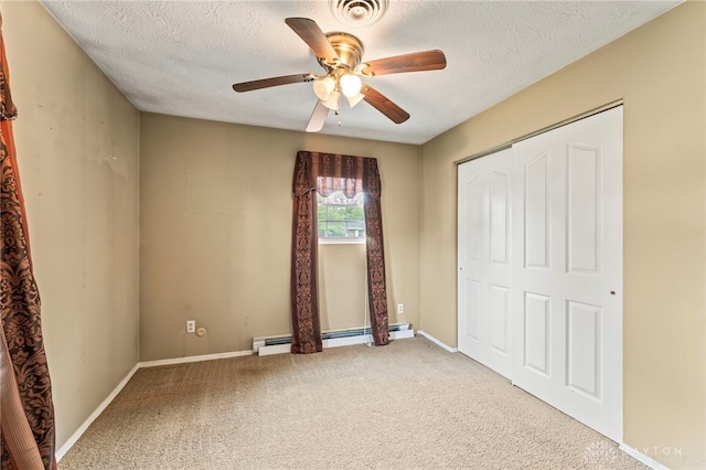 668 Dakota Dr, Xenia, OH 45385 - unfurnished bedroom with a baseboard heating unit, carpet, a textured ceiling, a closet, and baseboards