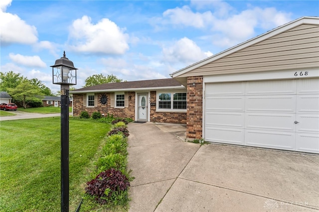 668 Dakota Dr, Xenia, OH 45385 - ranch-style house with driveway, a front yard, brick siding, and an attached garage