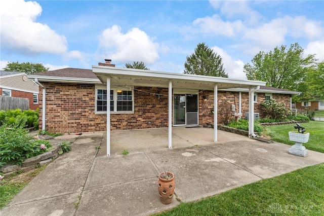668 Dakota Dr, Xenia, OH 45385 - rear view of property featuring a chimney, a patio, and brick siding