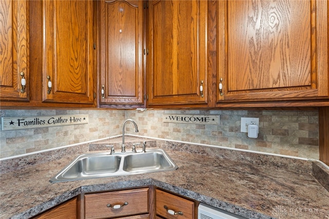 668 Dakota Dr, Xenia, OH 45385 - kitchen featuring a sink, brown cabinets, and decorative backsplash