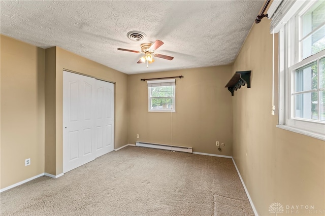 668 Dakota Dr, Xenia, OH 45385 - unfurnished bedroom featuring a baseboard heating unit, carpet flooring, a textured ceiling, a closet, and baseboards