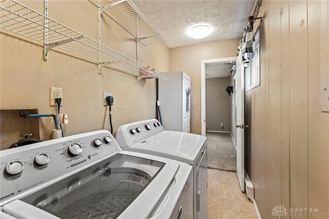 668 Dakota Dr, Xenia, OH 45385 - laundry area with washer and clothes dryer, a textured ceiling, and light tile patterned floors