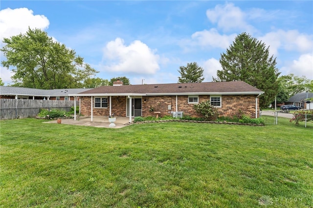 668 Dakota Dr, Xenia, OH 45385 - rear view of property with a patio, a chimney, and brick siding
