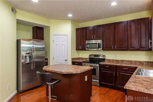 2385 Gerard Ct, Fairborn, OH 45324 - kitchen with stainless steel appliances, dark wood-style floors, a center island, a textured ceiling, and recessed lighting