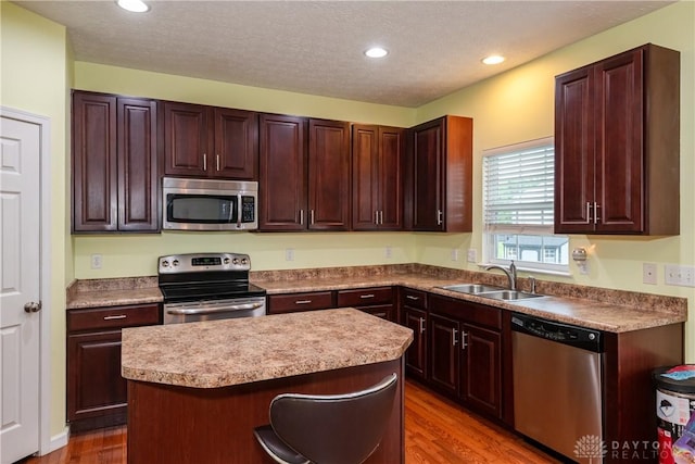 2385 Gerard Ct, Fairborn, OH 45324 - kitchen with appliances with stainless steel finishes, a sink, a center island, wood finished floors, and recessed lighting