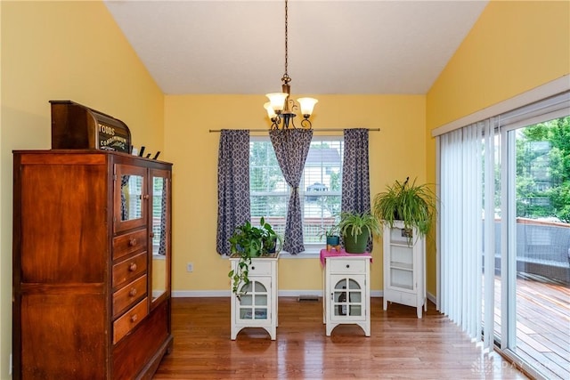 2385 Gerard Ct, Fairborn, OH 45324 - dining area featuring a chandelier, vaulted ceiling, wood finished floors, and baseboards