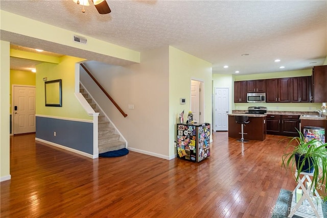 2385 Gerard Ct, Fairborn, OH 45324 - kitchen featuring appliances with stainless steel finishes, a sink, hardwood / wood-style flooring, a kitchen island, and baseboards