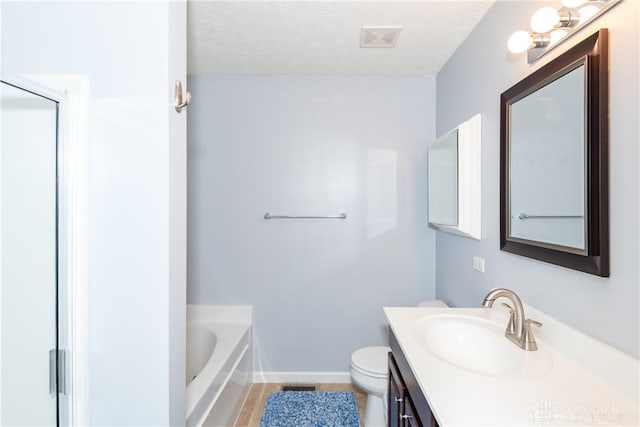 2385 Gerard Ct, Fairborn, OH 45324 - bathroom with vanity, toilet, a garden tub, baseboards, and a textured ceiling