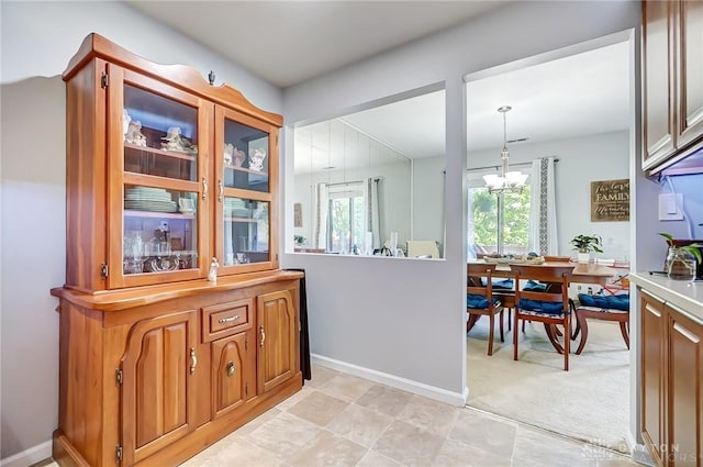 1357 Tattersall Rd Unit 70, Dayton, OH 45459 - kitchen featuring a chandelier, brown cabinets, light countertops, light carpet, and decorative light fixtures