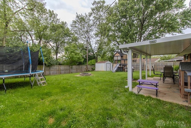 5864 Beecham Dr, Huber Heights, OH 45324 - view of yard featuring a trampoline, a patio, and a fire pit