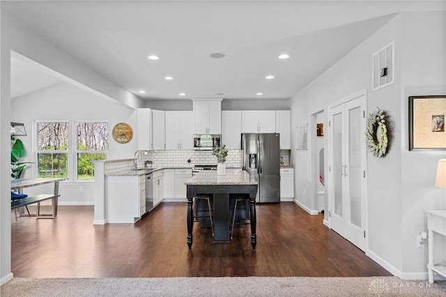 4069 Fawn Crossing Dr, Mason, OH 45040 - kitchen featuring appliances with stainless steel finishes, a kitchen breakfast bar, light stone countertops, decorative backsplash, and recessed lighting