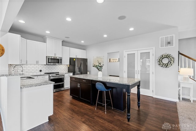 4069 Fawn Crossing Dr, Mason, OH 45040 - kitchen featuring appliances with stainless steel finishes, a sink, a center island, a breakfast bar, and decorative backsplash
