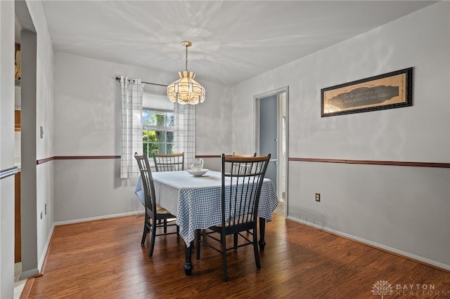 6719 Morrow Dr, Clayton, OH 45415 - dining area with a chandelier, wood finished floors, and baseboards